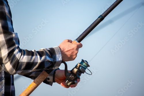 Close-up of fishing rod reels. Fishing on the shore of the lake. Spinning rods for sport fishing. photo