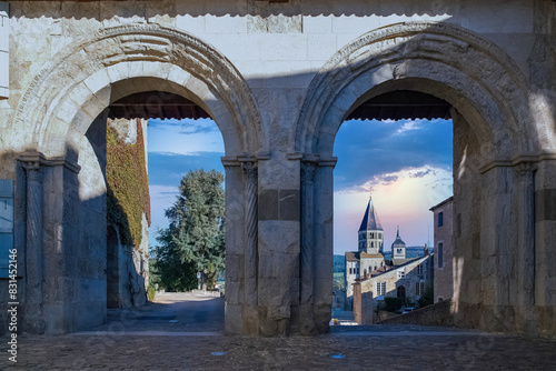 Historic Cluny Abbey monastery through a stone arch at sunset in Burgundy, France photo