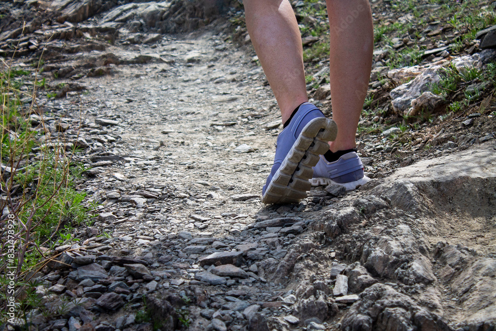 Young woman on a short hike in rocky area, just the feet and legs Young woman on a short hike in rocky area, just the feet and legs