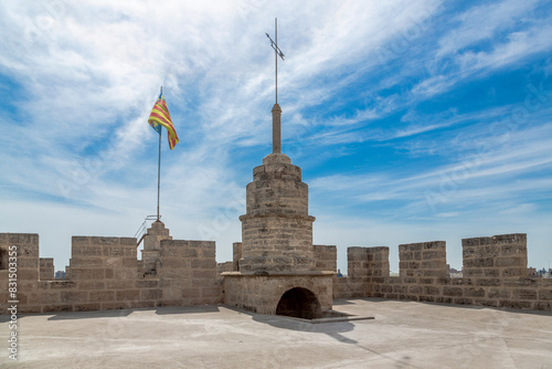 Penell y acceso a la terraza superior, Torres de Serrans. Terraza de las Torres de Serranos con un pináculo sosteniendo una paleta de Clima, al fondo se encuentra la bandera de Valencia, España.