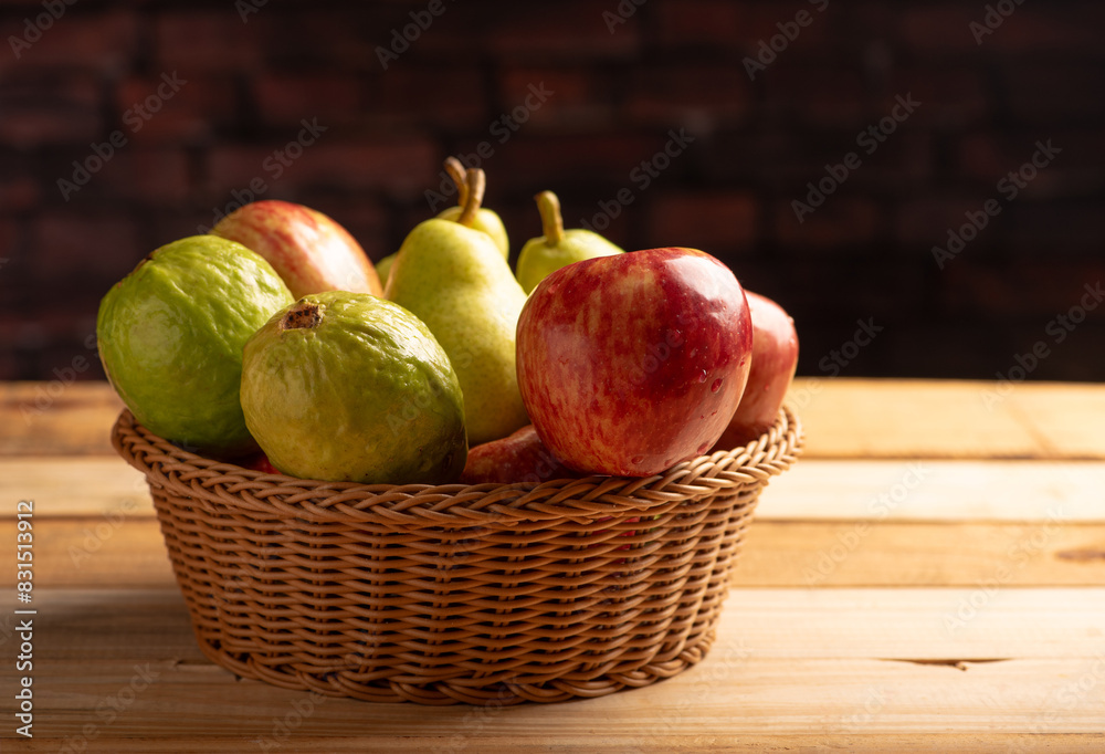 Basket with fruits on rustic wooden surface and dark background, selective focus. Basket with fruits on rustic wooden surface and dark background, selective focus.