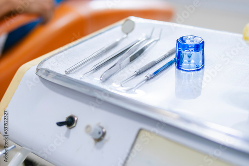 Close-up of dental implements, including: dental mirror, dental explorers, dental tweezers, amalgam carrier, amalgam, resin, cleaning instruments, curettes, scalers