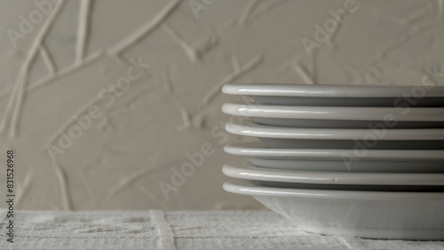 White plates stacked on a table with white tablecloth