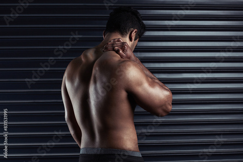 Neck pain, athlete and man with injury and body ache in fitness training, exercise or workout. Dark background, sore muscles or sports person with bruised spine in accident, gym studio or emergency