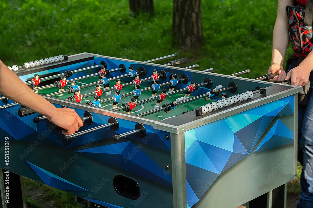 Fototapeta premium Mens playing table football outdoors.