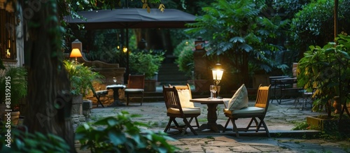 Romantic patio in park at night with garden lamp, benches, pillow and table .