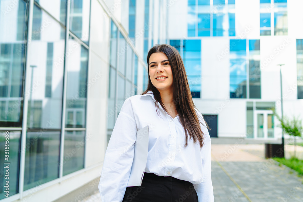 One young successful business woman going to work at business office modern building while holding coffee and papers One young successful business woman going to work at business office modern building while holding coffee and papers