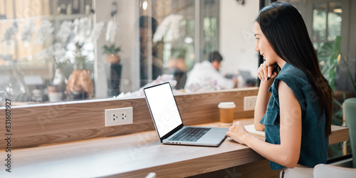 Εκτύπωση καμβά A woman is sitting at a table with a laptop in front of her