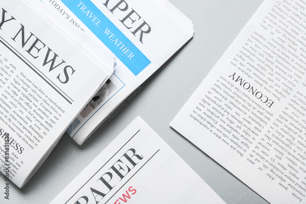 Obraz premium Different newspapers on grey background