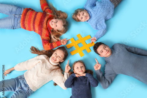 Group of cute kids lying with hashtag on blue background