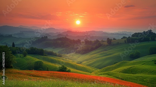 a beautiful sunset over a green hilly landscape with a few trees