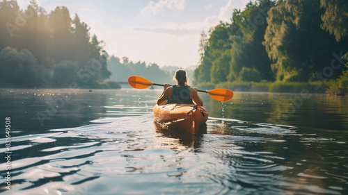 Woman kayaking on serene river surrounded by lush green forest under calm sky