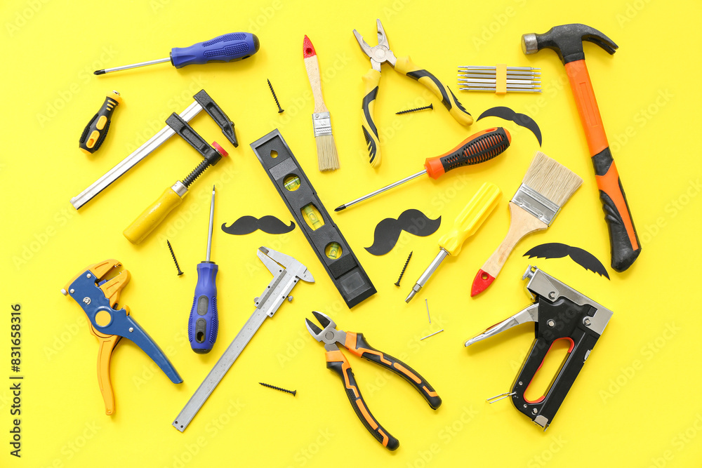 Tools and paper mustaches on yellow background. Father's Day celebration Tools and paper mustaches on yellow background. Father's Day celebration