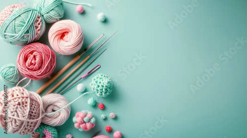 assorted knitting yarn and crochet tools on pastel teal background with copy space