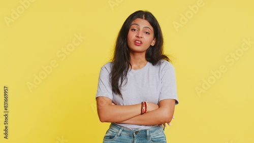 Indian young woman tired bored indifferent expression, exhausted of tedious story, not interested in communication talk, displeasure, uninteresting. Arabian girl isolated on yellow background indoors photo