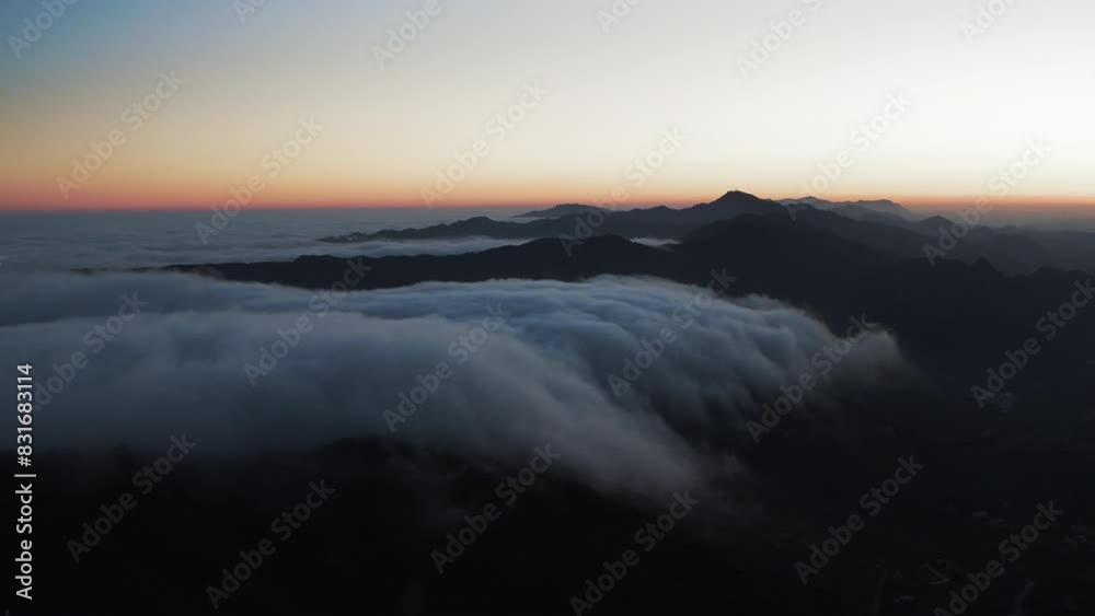 Aerial Backward Idyllic View Of Mountain Range In Fluffy Clouds During Tranquil Sunset - Calico Bluff, Alaska Aerial Backward Idyllic View Of Mountain Range In Fluffy Clouds During Tranquil Sunset - Calico Bluff, Alaska