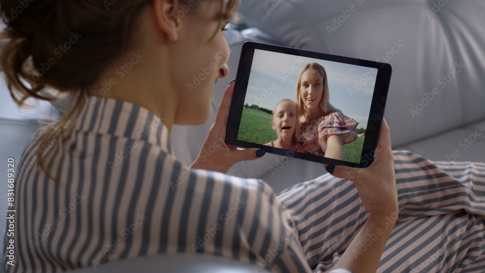 Woman videocalling tablet screen at home closeup. Happy friends talking online