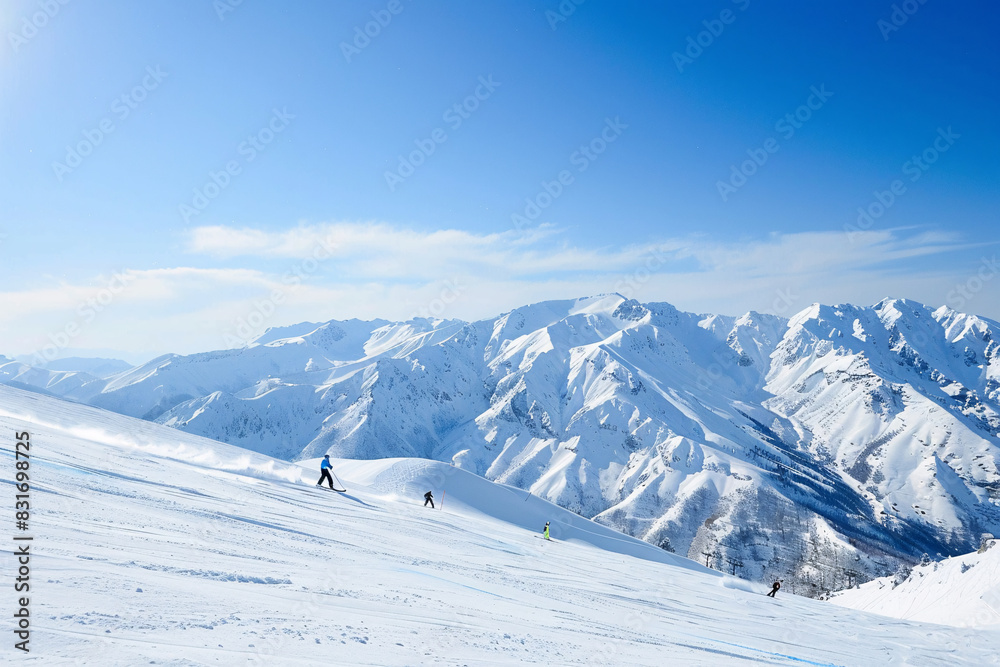 Skiers descending a snowy mountain slope under a clear blue sky Stock Photo with copy space Skiers descending a snowy mountain slope under a clear blue sky Stock Photo with copy space