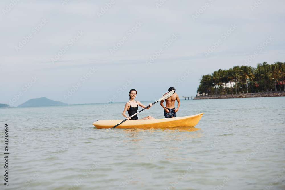 Adventurous Couple Enjoying Carefree Kayaking Fun on Beautiful Tropical Water Surface at Sunset