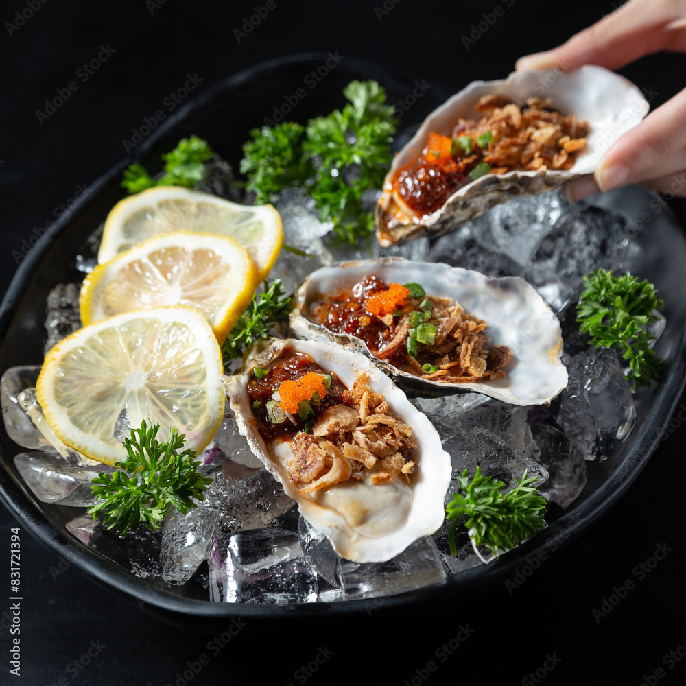 Top view of people with fresh oysters at table, focus on hands Top view of people with fresh oysters at table, focus on hands
