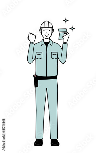 Man in helmet and workwear who is pleased to see a bankbook.