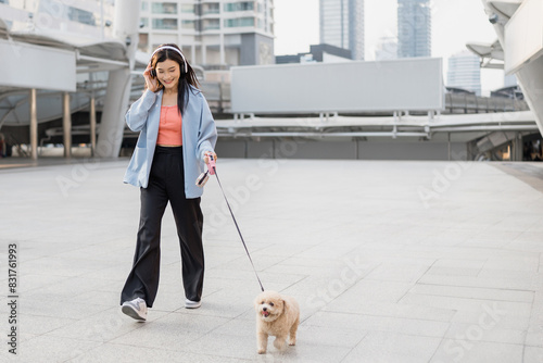 Asian young woman walking with her adorable small puppy in the city.  photo