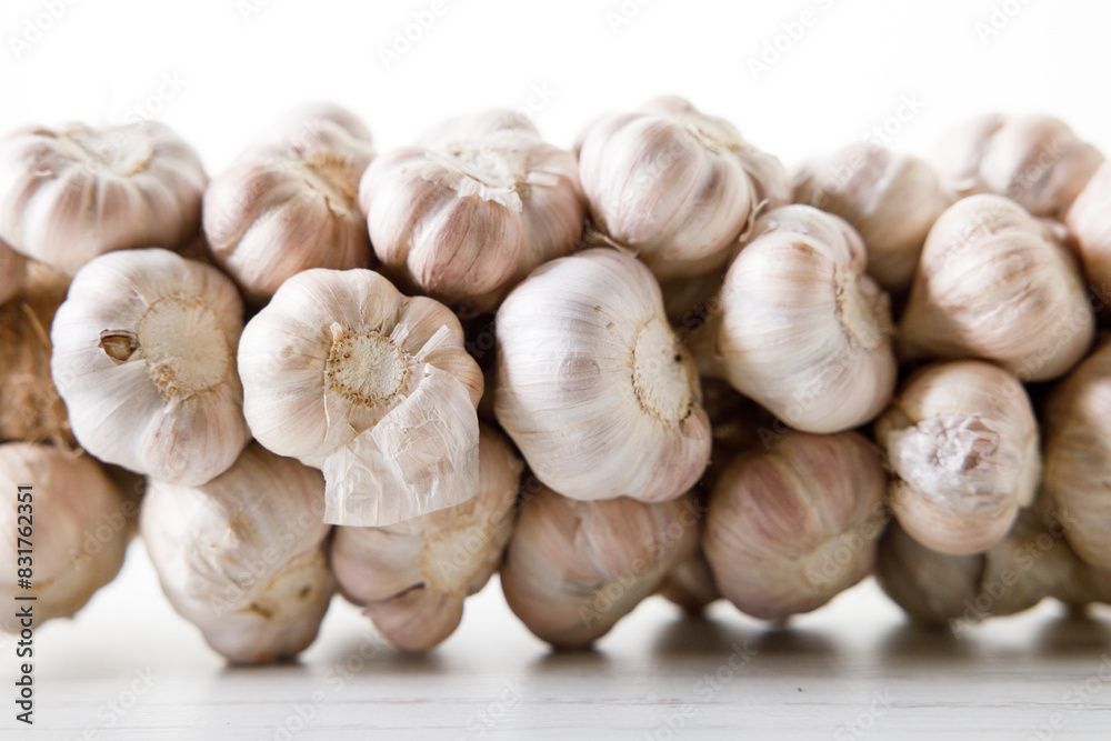 Ripe organic garlic clove and bulb on white wooden background. Close-up. Selective focus. Ripe organic garlic clove and bulb on white wooden background. Close-up. Selective focus.