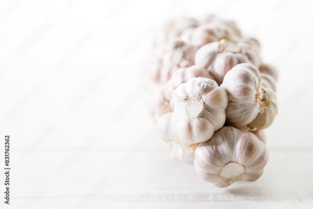 Ripe organic garlic clove and bulb on white wooden background. Close-up. Selective focus. Ripe organic garlic clove and bulb on white wooden background. Close-up. Selective focus.