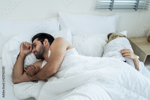 Caucasian young couple lying on bed with painful after fight argument. 