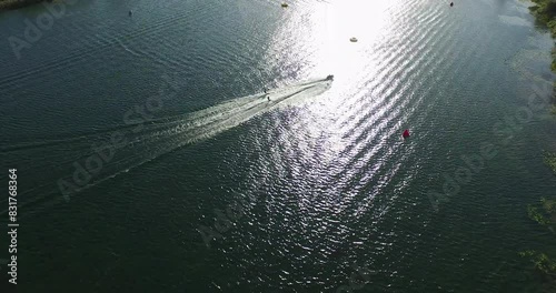 Extra wide shot looking down on jet ski and lake boarders on sparking body of water - drone photo