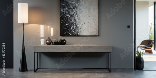 A minimalist and modern entryway with a polished concrete floor  a simple and functional console table  and a large piece of abstract art on the wall.