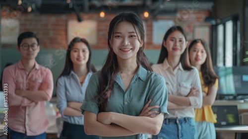 Group of Asia young creative people in smart casual wear smiling and arms crossed in a creative office workplace. Diverse Asian males and females stand together at startup. Coworker teamwork concept.