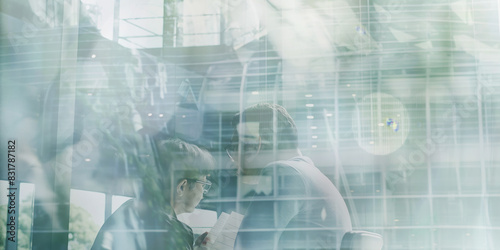 A double exposure photograph showcasing a diverse team of business professionals engaging in a strategic discussion within a sleek, modern office setting.