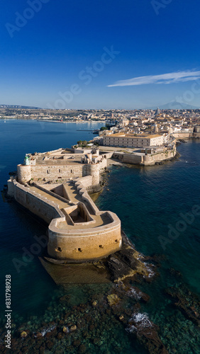 Siracusa Vista dal Mare. Sullo sfondo, l'Etna, sulla sinistra, nel Porto Grande, delle barche a vela.  photo