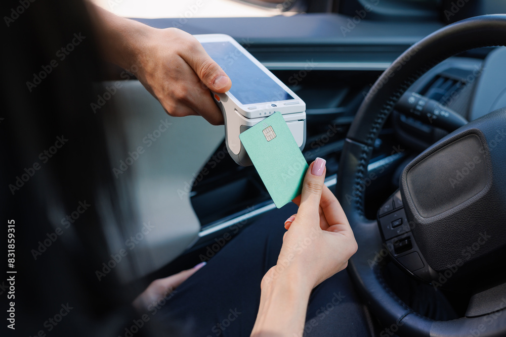 a girl makes contactless payment with a smartphone while sitting in a car, a girl makes contactless payment with a smartphone while sitting in a car,