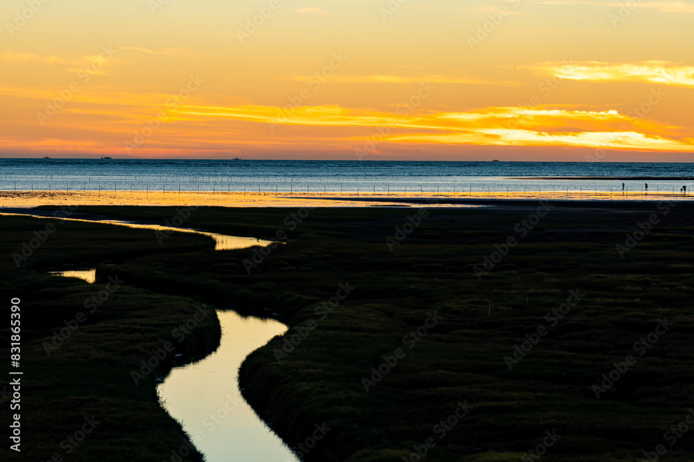 Fototapeta premium Gaomei Wetlands in sunset time. Sea shore, river, rosy clouds, a beautiful scenery.