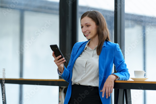 African businesswoman American uses smartphone while working on laptop at office Businesswoman working on the phone online applications Success concept, relaxation, online ordering. © crizzystudio