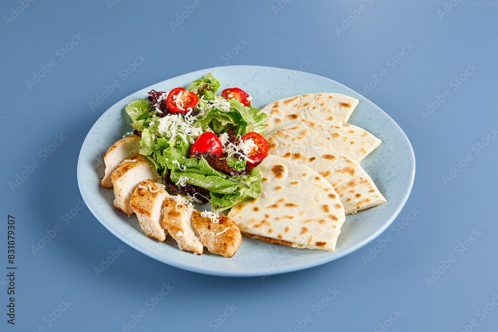 Healthy Caesar Salad with Chicken and Tortilla on Blue Background Healthy Caesar Salad with Chicken and Tortilla on Blue Background