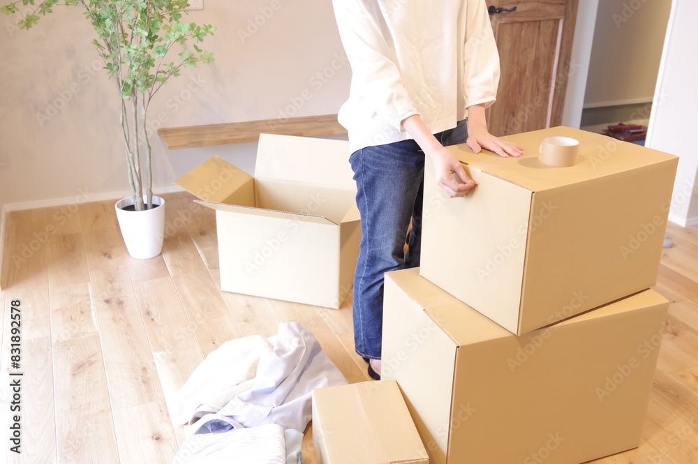 段ボールに荷物をまとめる女性 段ボールに荷物をまとめる女性