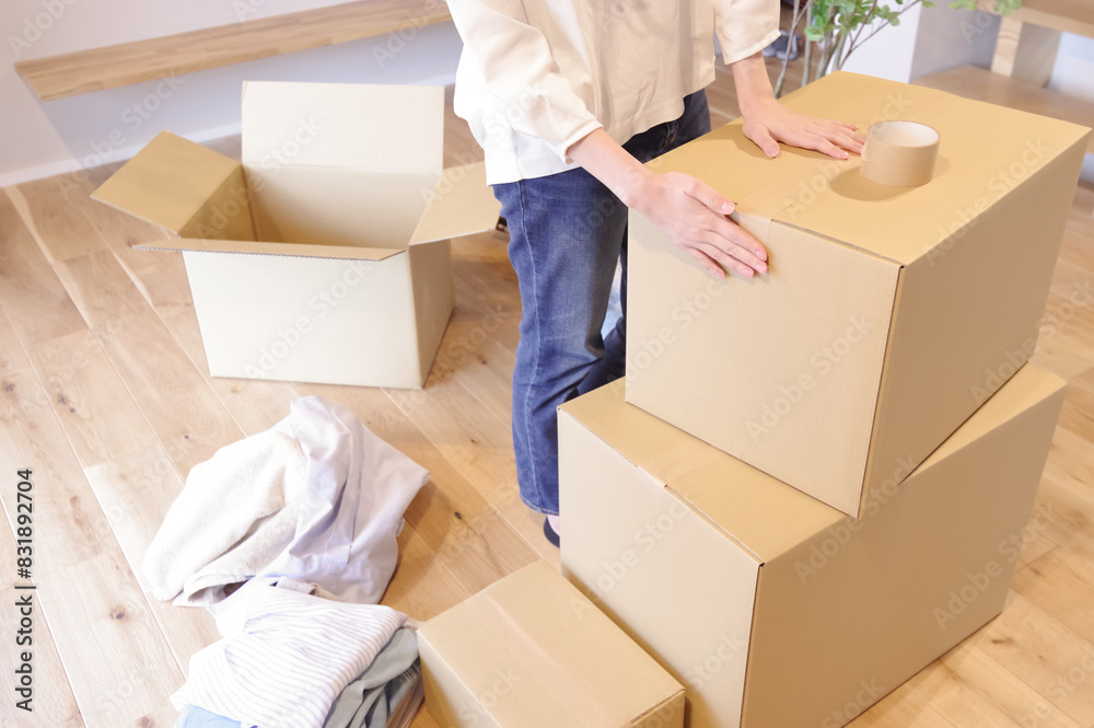 段ボールに荷物をまとめる女性 段ボールに荷物をまとめる女性