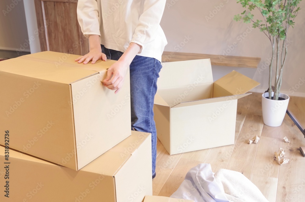 段ボールに荷物をまとめる女性 段ボールに荷物をまとめる女性