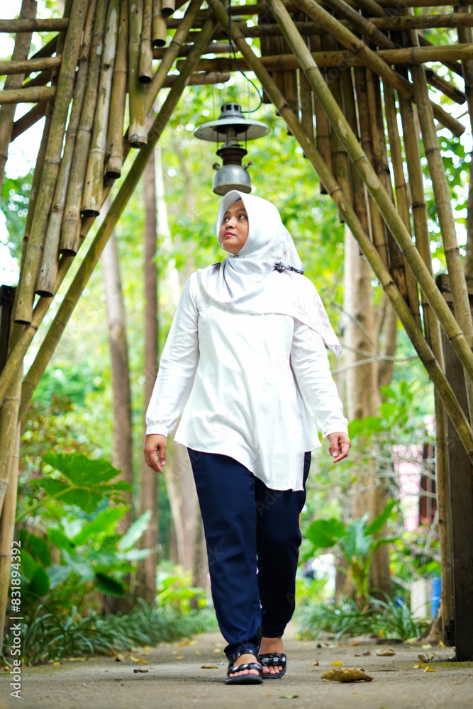 Asian female model in white hijab is in the park