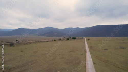 A beautiful landscape drone video of an empty field with a road in Croatia region Lika in Europe (ID: 831895593)