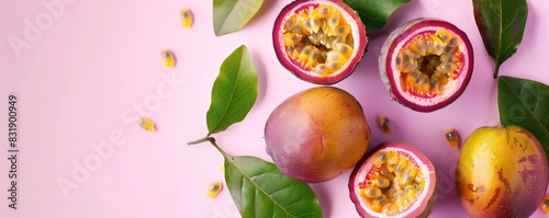 Top view of ripe passion fruits with leaves sliced in half on a pink textured background, emphasizing freshness and tropical flavor.