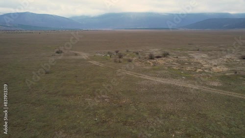 A beautiful landscape drone video of an empty field with a road in Croatia region Lika in Europe (ID: 831903319)
