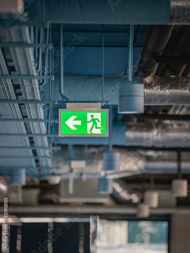 Emergency exit sign. Office spaces. Industrial ceiling
