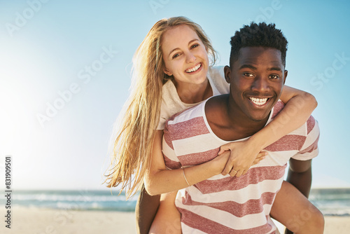 Face, piggy back and beach with couple, love and sunshine with happiness, interracial and adventure. Portrait, seaside and man carrying woman with vacation, romance and summer with honeymoon or break