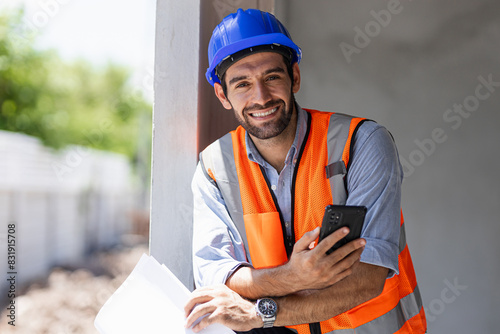 Wallpaper Mural A chief engineer in a hard hat walks through modern factory lighting while holding a laptop. Successful handsome man in a modern industrial environment. Torontodigital.ca