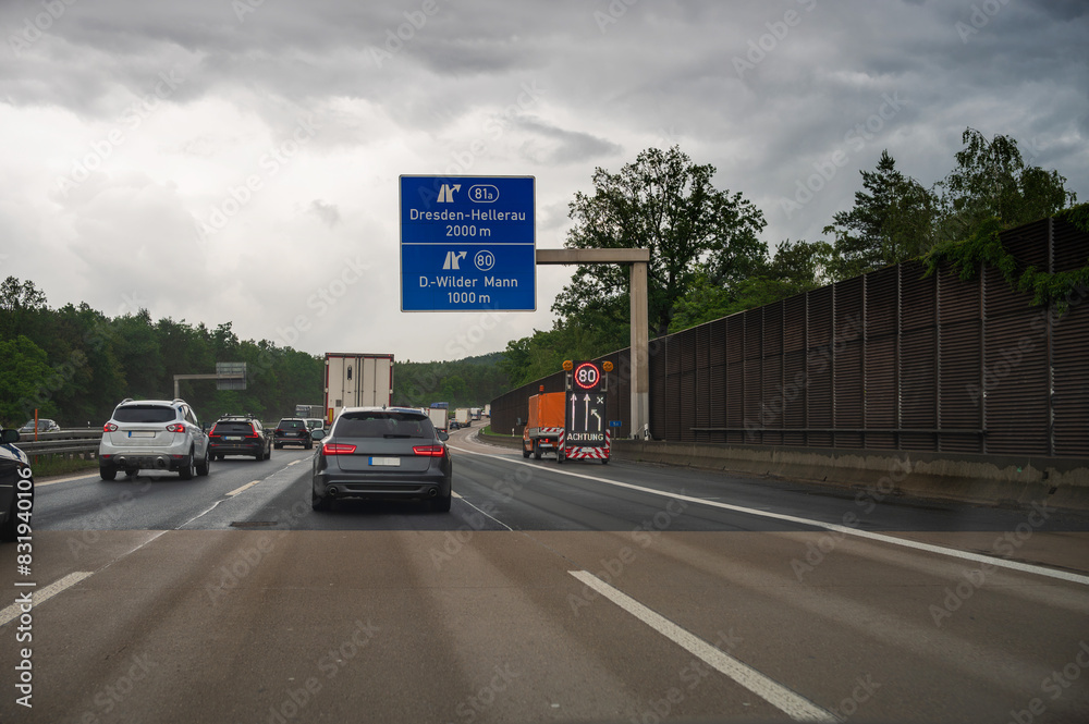 Ein Baustellenfahrzeug auf der Autobahn mit einem Hinweis auf eine Geschwindigkeitsbeschränkung