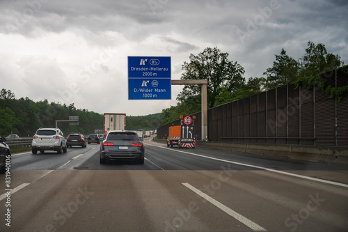 Obraz na płótnie Ein Baustellenfahrzeug auf der Autobahn mit einem Hinweis auf eine Geschwindigkeitsbeschränkung w salonie